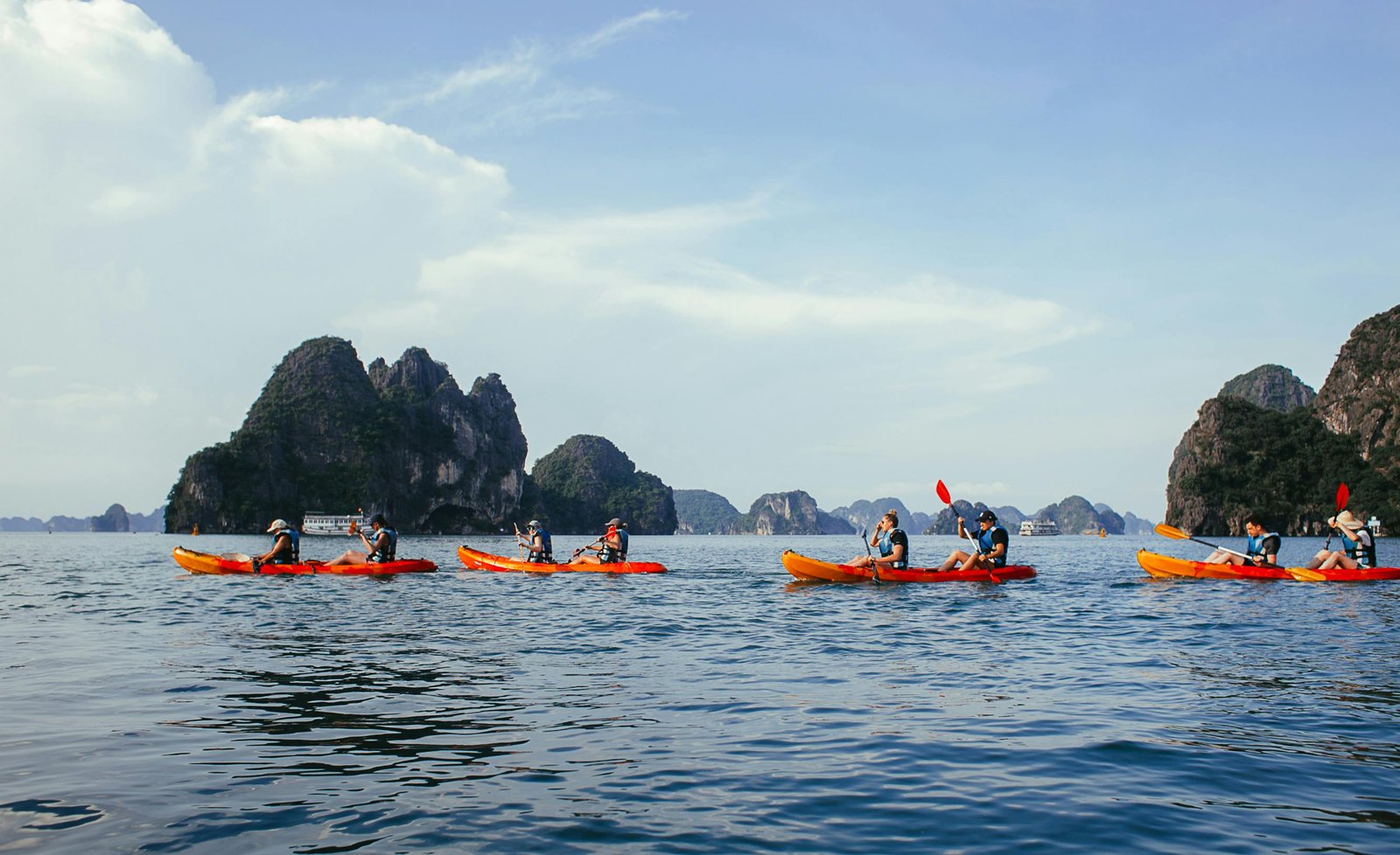 A group of kayakers enjoying the ocean amidst stunning limestone formations.